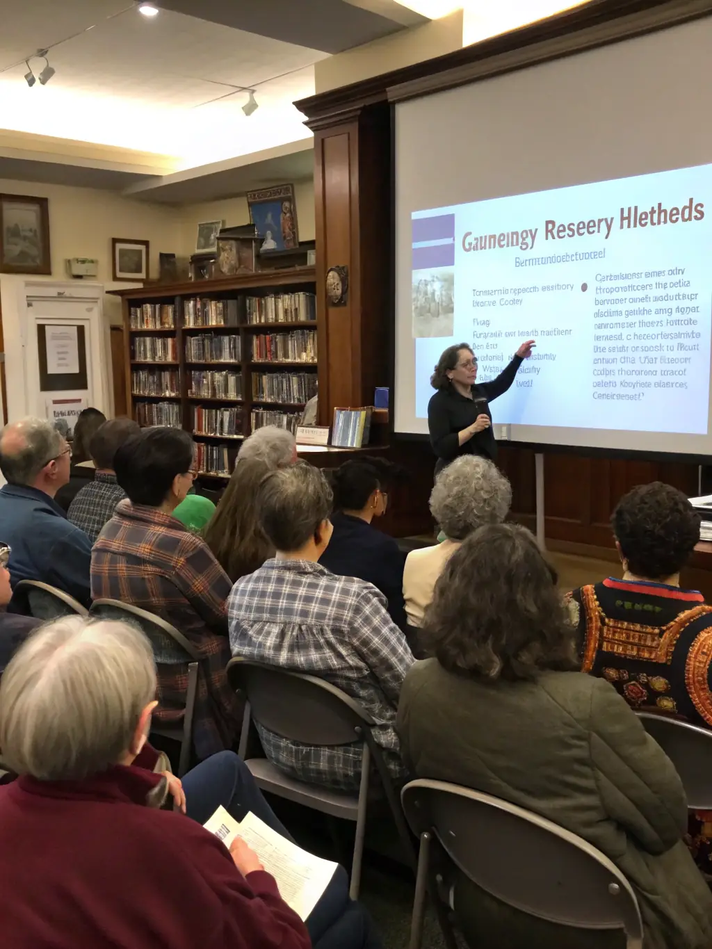 A photo of community members attending a local history presentation at the Cozes library, featuring historical documents and artifacts.